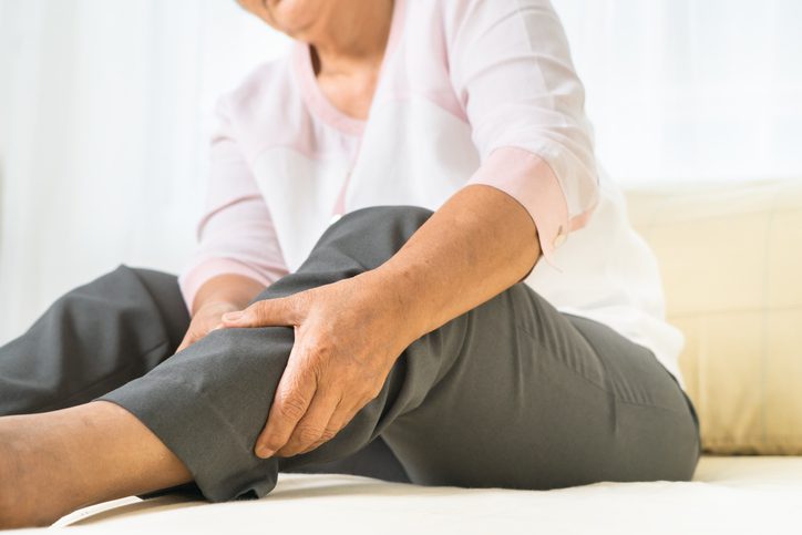 woman holding swollen leg